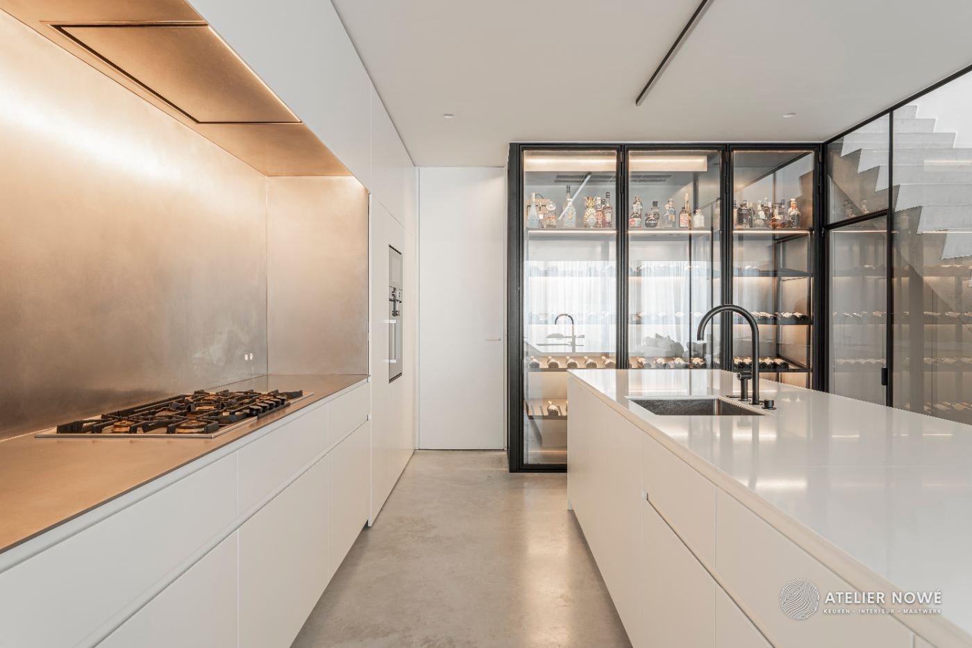 Witte keuken op maat met kookwand in inox, kookeiland en glazen wijnwand, project in Astene door Atelier Nowé